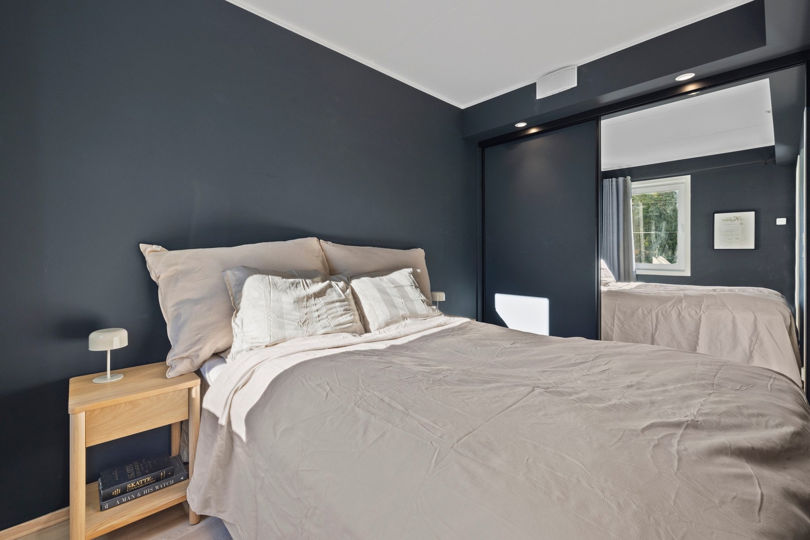 Veggene er malt i en mørk blåtone - rommet inviterer til en god natts søvn. Galleribilde