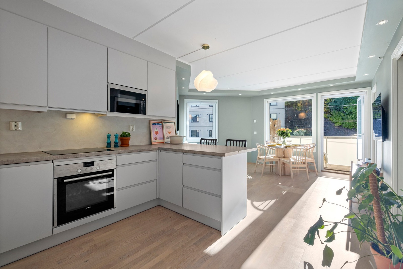 Åpen kjøkkenløsning mot stuen skaper en sømløs overgang som legger til rette for gode samtaler mens middagen tilberedes. Galleribilde