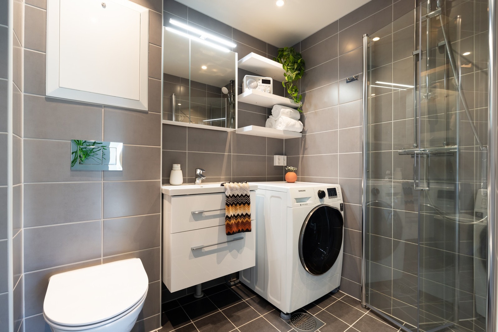 På badet er det baderomsinnredning med to skuffer, servant, samt speilskap med belysning over. Det er også tre hyller med fin plass til oppbevaring av håndklær og det man måtte ønske. Videre er det vegghengt toalett og dusjvegger/hjørne. Galleribilde