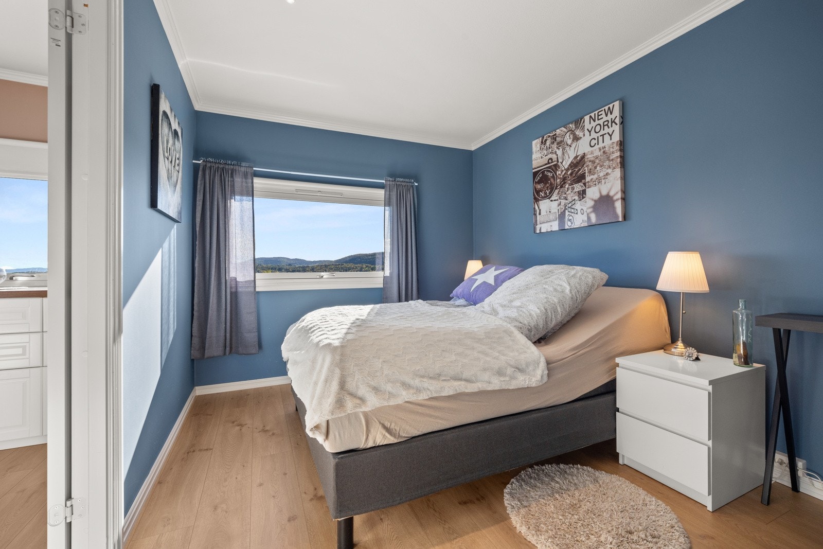 Romslig soverom med plass til dobbeltseng og nattbord Galleribilde