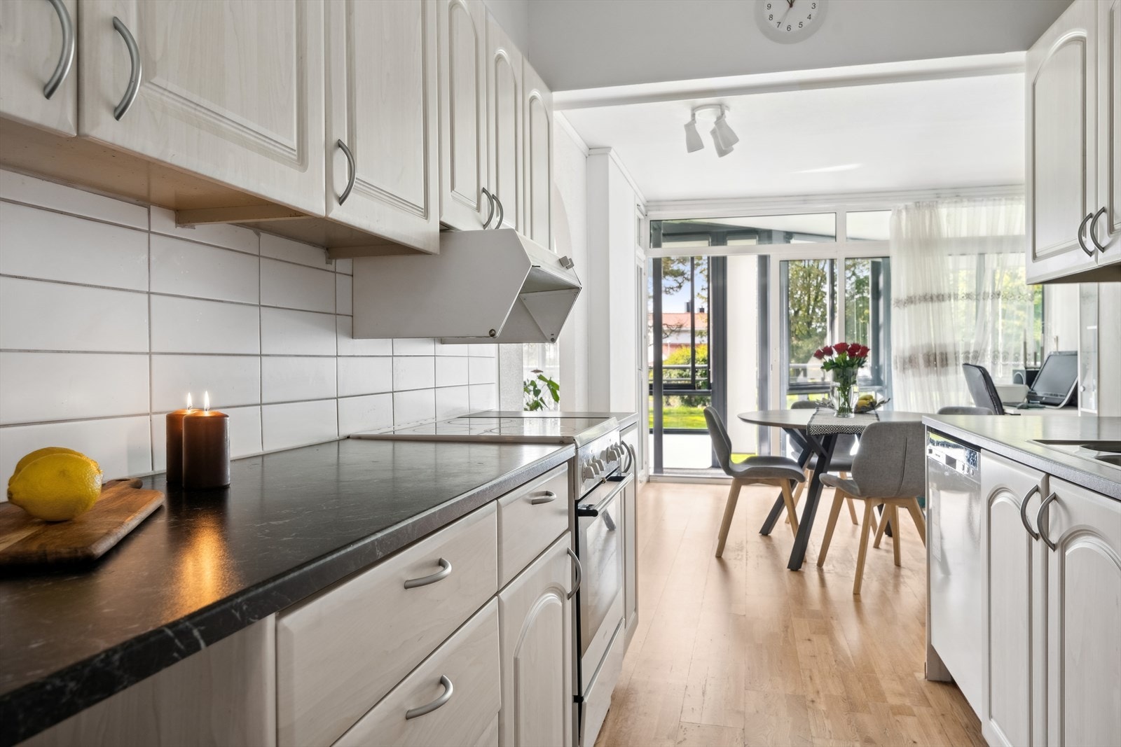 Kjøkkenet ligger i eget rom. Innredningen som går over to sider har hvite, profilerte fronter, benkeplate i laminat, hvite fliser over benkeplaten og lys under overskap som sikrer godt opplyste arbeidsområder. Galleribilde