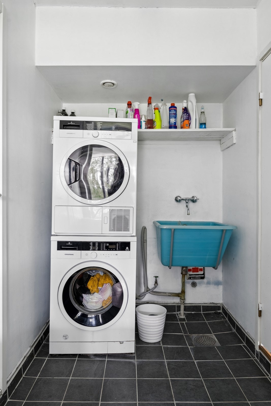 Praktisk, separat vaskerom fra byggeår med flislagte overflater. Rommet er innredet med vaskekum og opplegg for vaskemaskin. Galleribilde