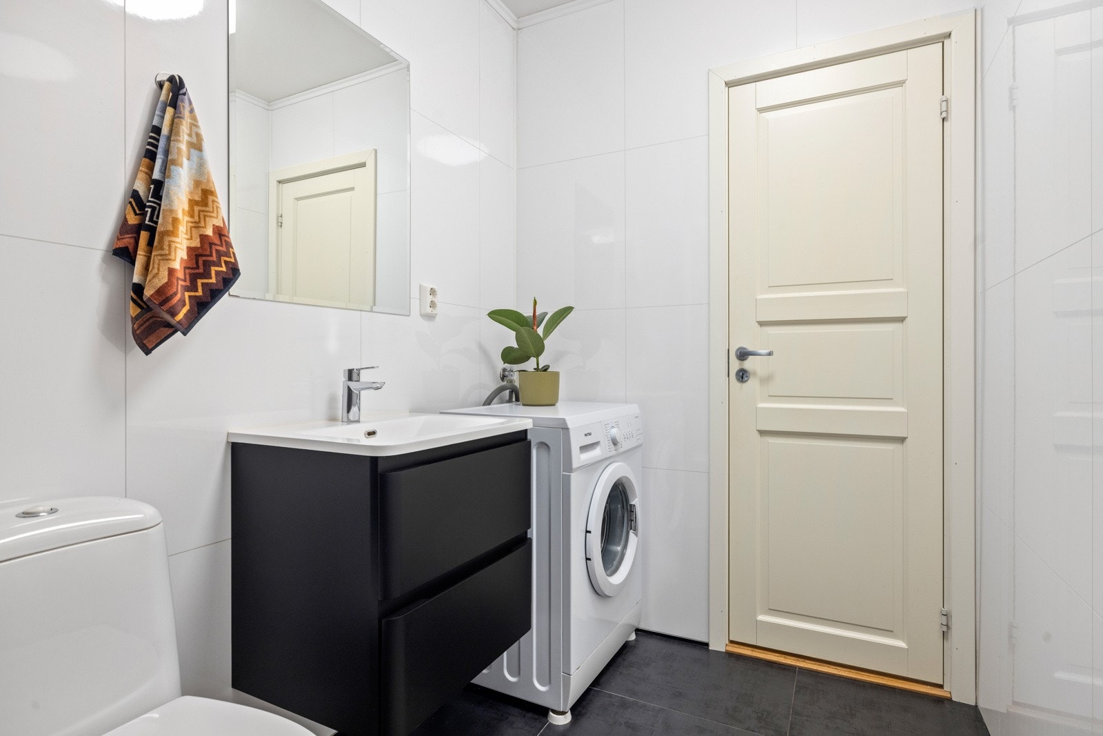 Badet har gulvstående klosett, dusjkabinett med glass, samt vegghengt servantskap med speil. Galleribilde