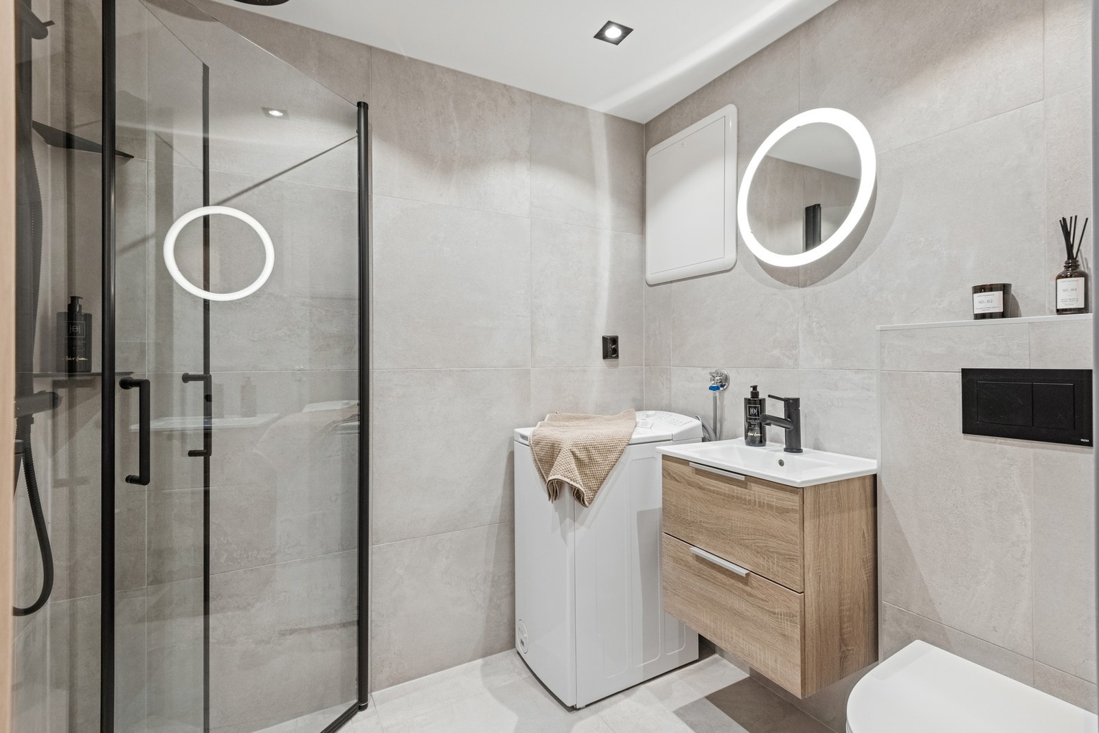 Flislagt bad med varmekabler i gulv, vegghengt WC og opplegg for vaskemaskin. Galleribilde