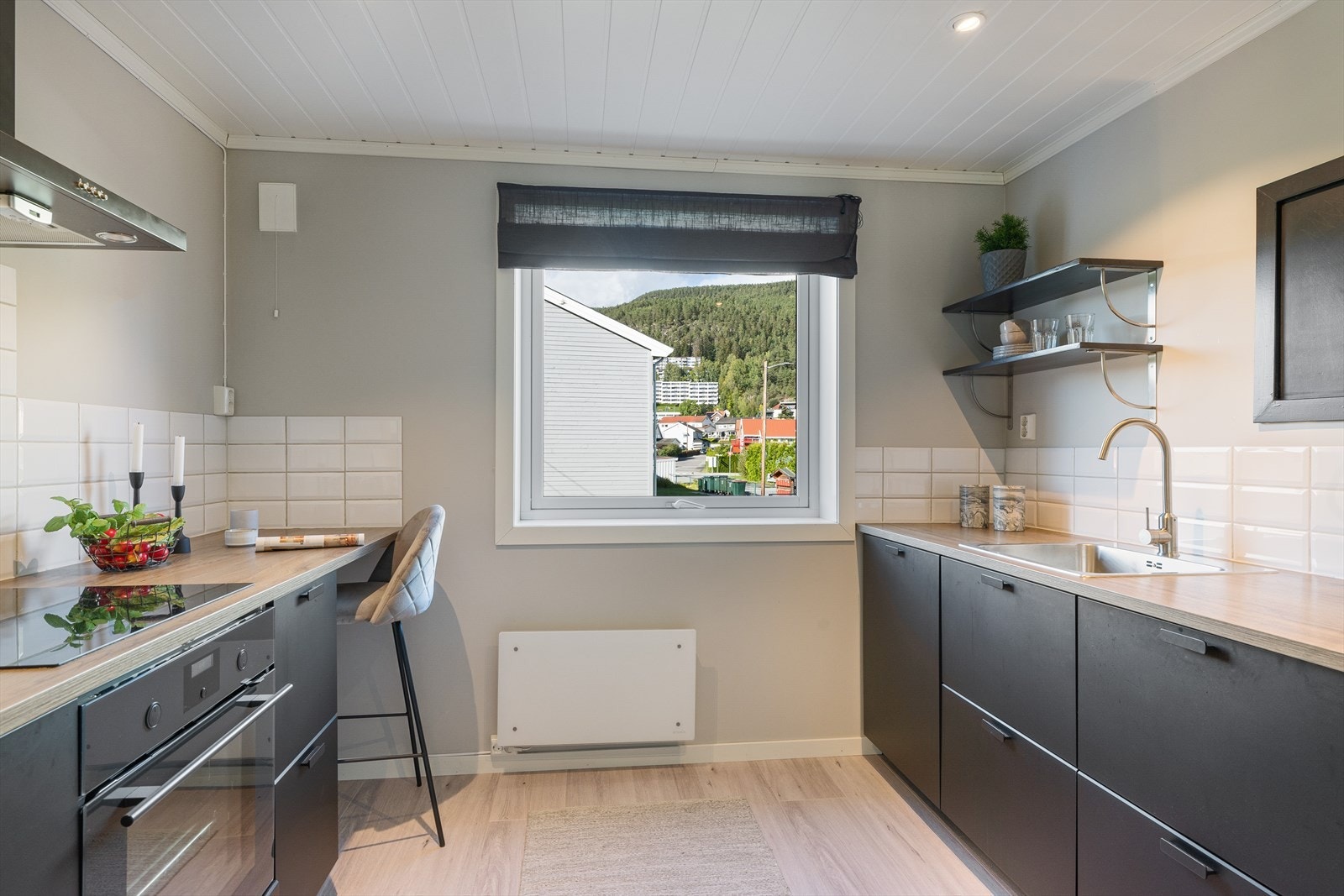 Kjøkkenet kombinerer moderne stil med funksjonell design, og byr på både praktiske løsninger og rikelig med skap- og benkeplass Galleribilde