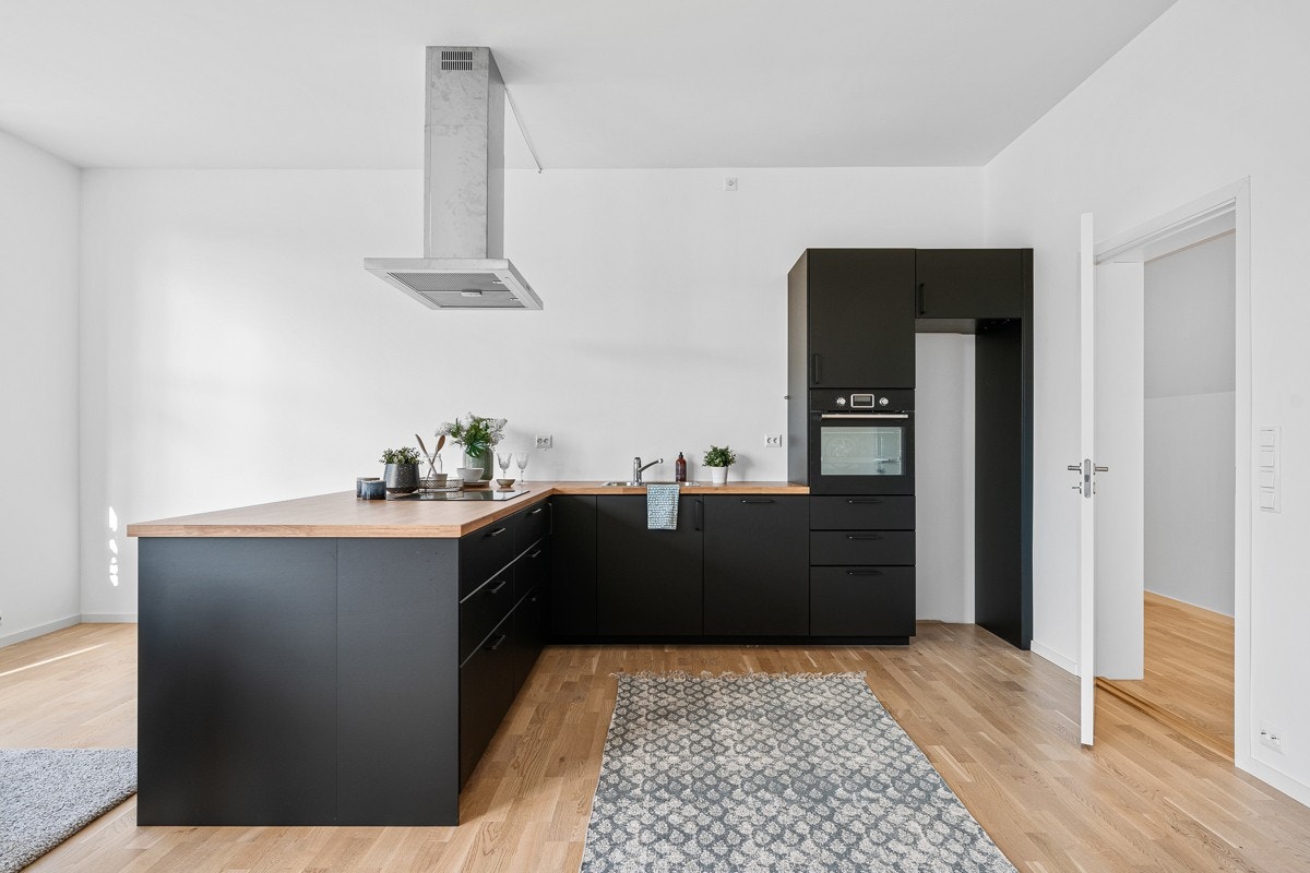 Kjøkkenet har en ny, stilig og moderne innredning med sorte, slette fronter. Galleribilde