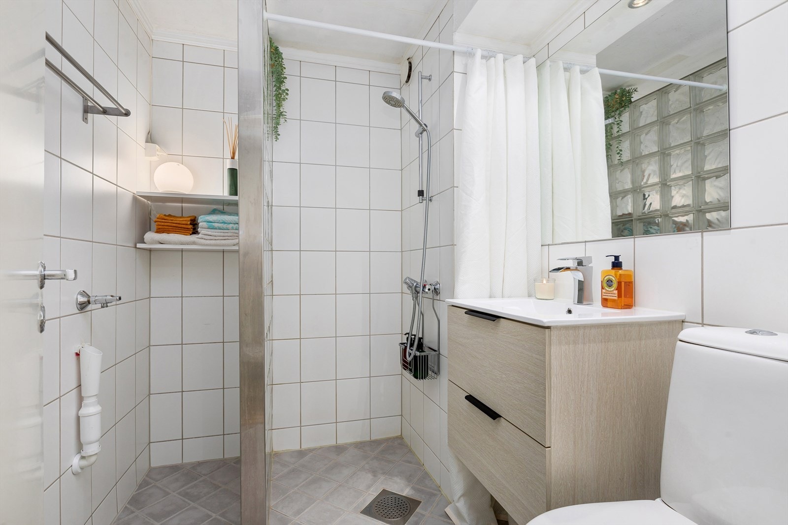 Alle badene i borettslaget skal totalrenoveres i 2025. Dagens bad er utstyrt med dusjhjørne, WC, servant i skuffeinnredning og opplegg for vaskemaskin. Galleribilde