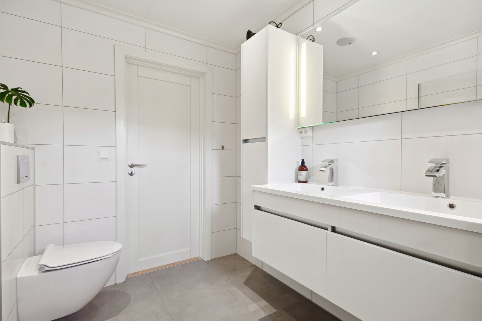 På badet er det hvit innredning med dobbel servant og skuffer Galleribilde