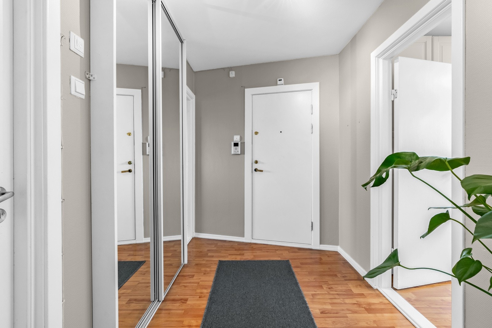 Entreen har dørcalling med åpner ved siden av ytterdøren, og en stor skyvedørsgarderobe innfelt i den ene veggen Galleribilde