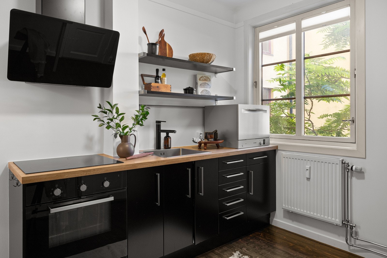 Kjøkkenet har en moderne innredning med mørke, slette fronter og stålhåndtak som gir et stilig og elegant uttrykk. Galleribilde