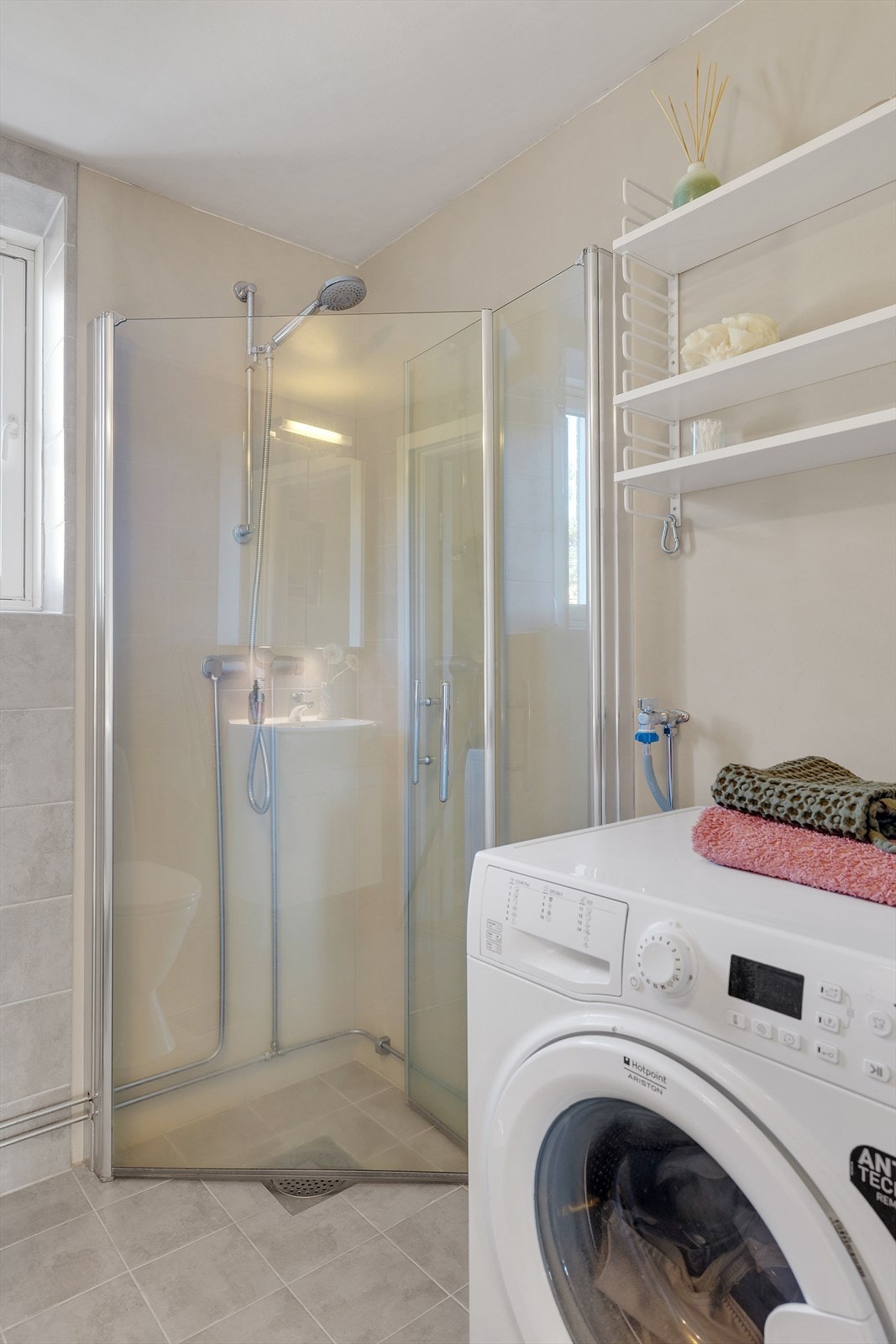 Pent baderom som inneholder dusj på gulv, toalett og servantinnredning - Opplegg og plass til vaskemaskin Galleribilde