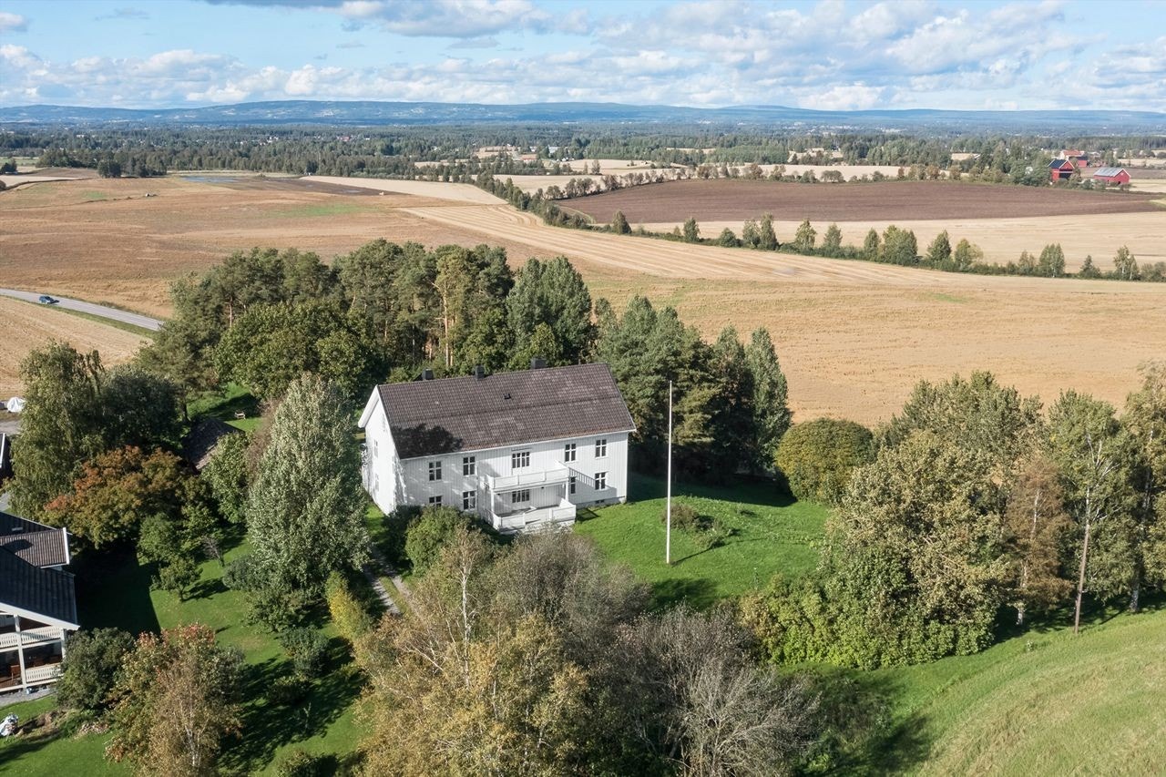 Eiendommen ligger på en liten høyde i landlige omgivelser rett ved Romedal kirke Galleribilde