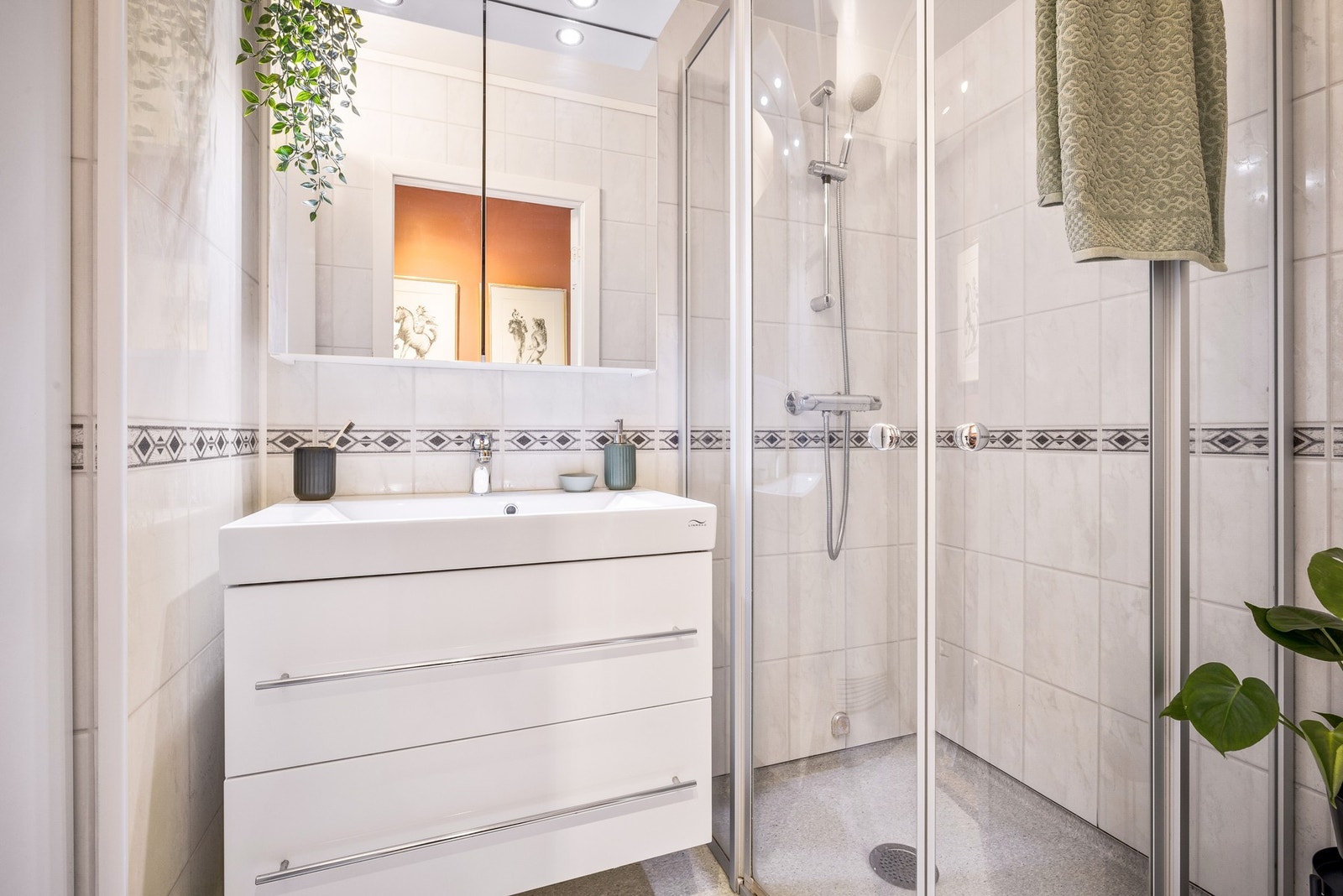 Lyst bad ca. fra 2012 innredet med servant, speilskap og dusjvegger Galleribilde