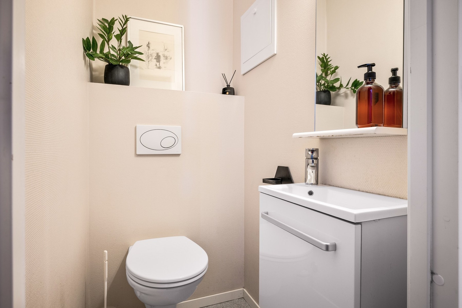 Adskilt WC-rom med veggengt toalett og servant Galleribilde