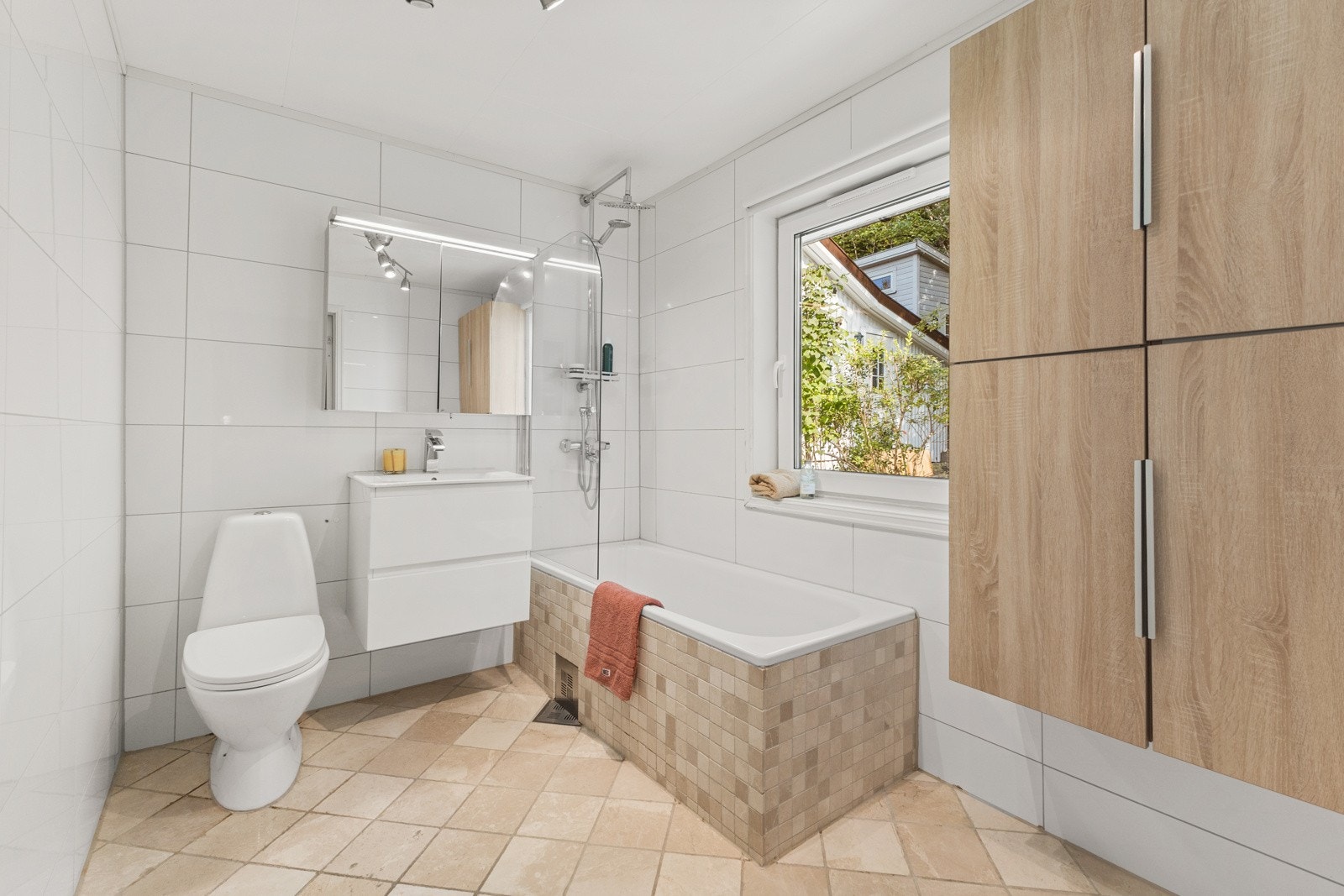 Flislagt baderom med gulvvarme beliggende i 1. etasje. Badet består av vegghengt servantskap med ovenpåliggende servant. Galleribilde