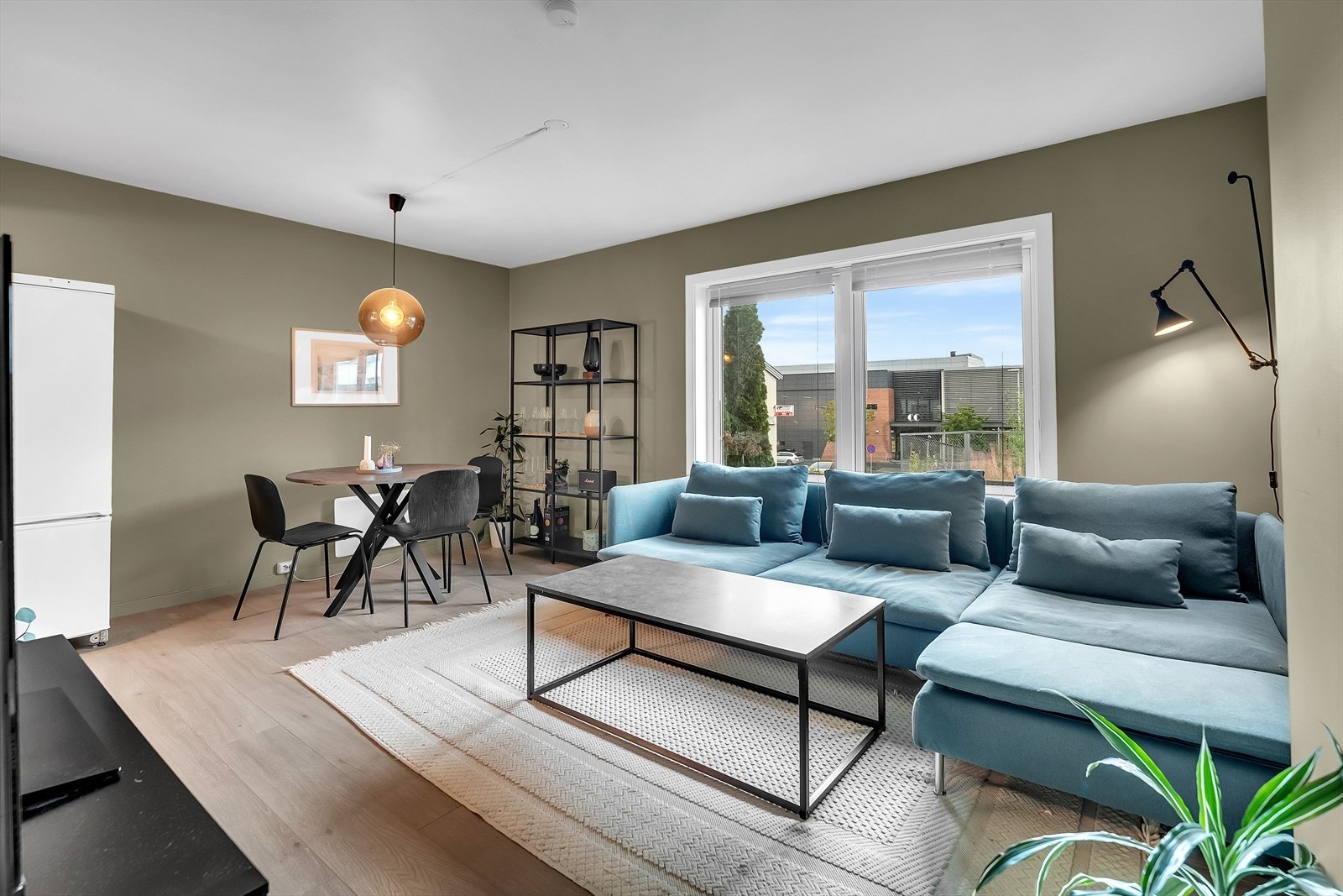 Leiligheten har en romslig oppholdsrom med god plass til sofa, spisegruppe og tilhørende møblement. Galleribilde