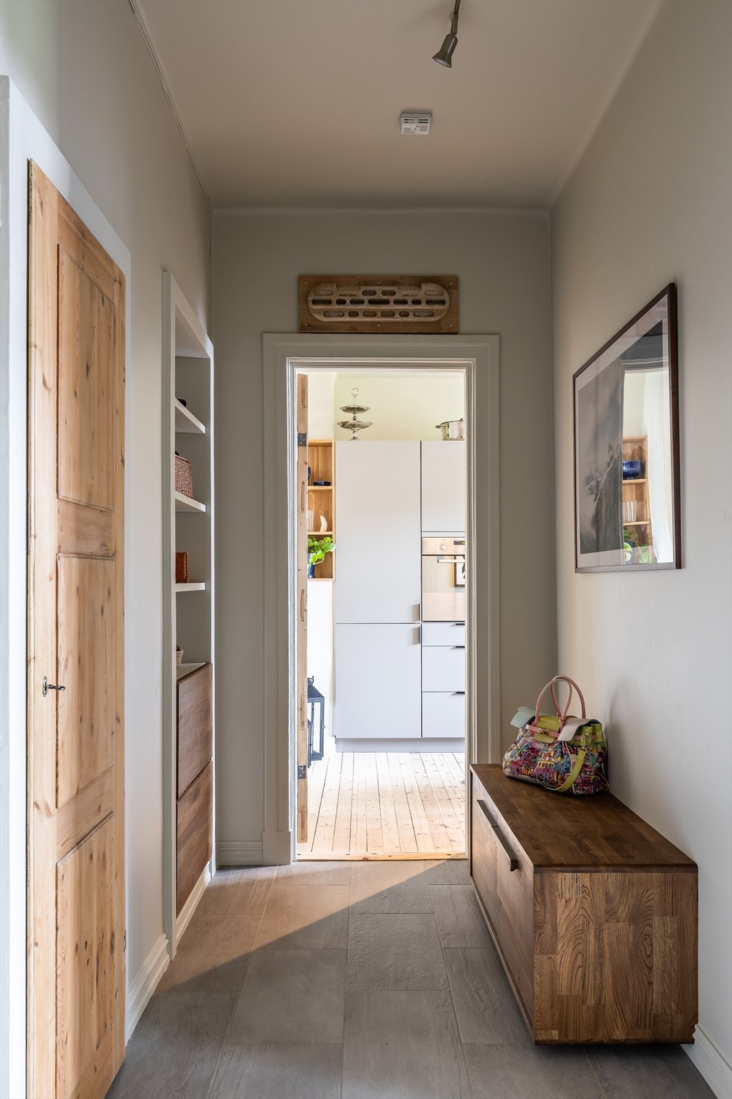 Romslig entré med plassbygget benk i eik for ekstra oppbevaringsmuligheter Galleribilde