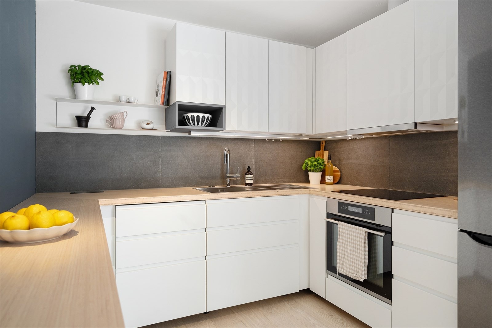 Tidsriktig innredning fra Ikea med glatte fronter, fliser på veggen over kjøkkenbenken og spesialbestilt heltre bambus-benkeplate Galleribilde