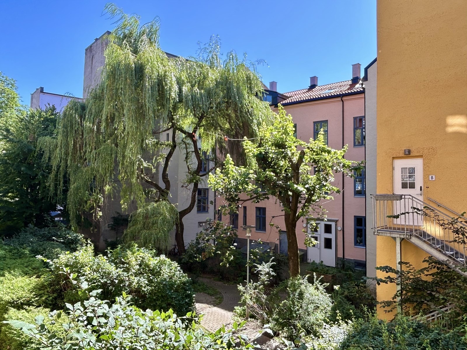 Fint utsyn mot frodig og blomstrende bakgård i fredfulle omgivelser. Selgers eget bilde fra balkongen Galleribilde
