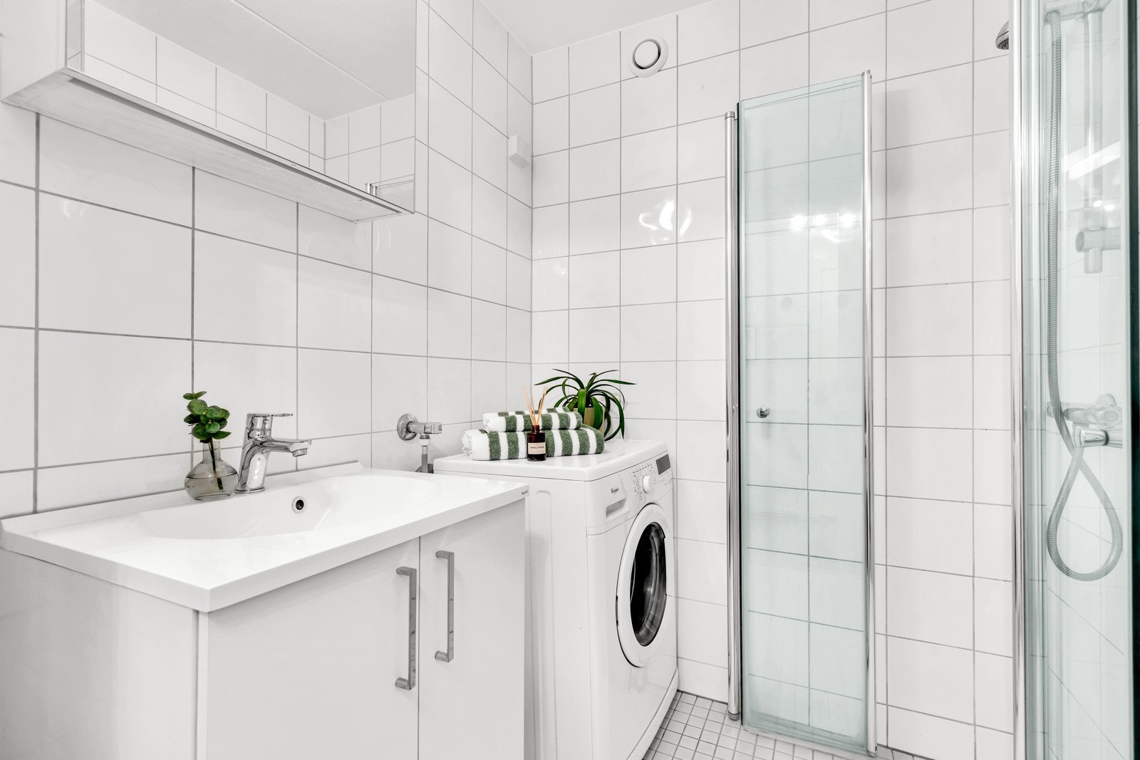 Flislagt bad med varmekabler i gulv og opplegg for vaskemaskin. Galleribilde