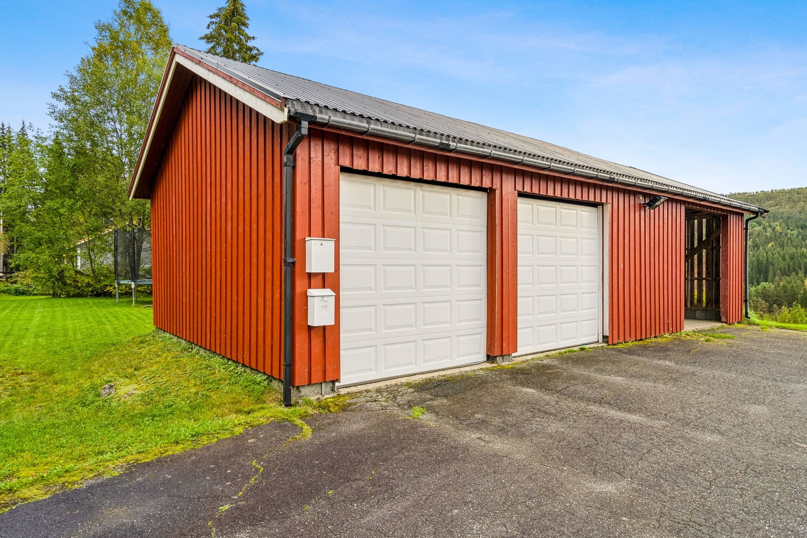 Garasjen har to leddporter av metall med motorstyring. Det ble lagt ny bordkledning i 2016. Galleribilde