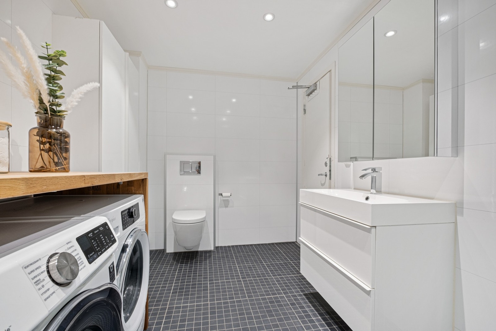 Bad/ vaskerom i sokkelen er på 7,5 kvm. Flis på gulv med gulvvarme, vegghengt klosett, opplegg til vaskemaskin og plass til tørketrommel. Galleribilde