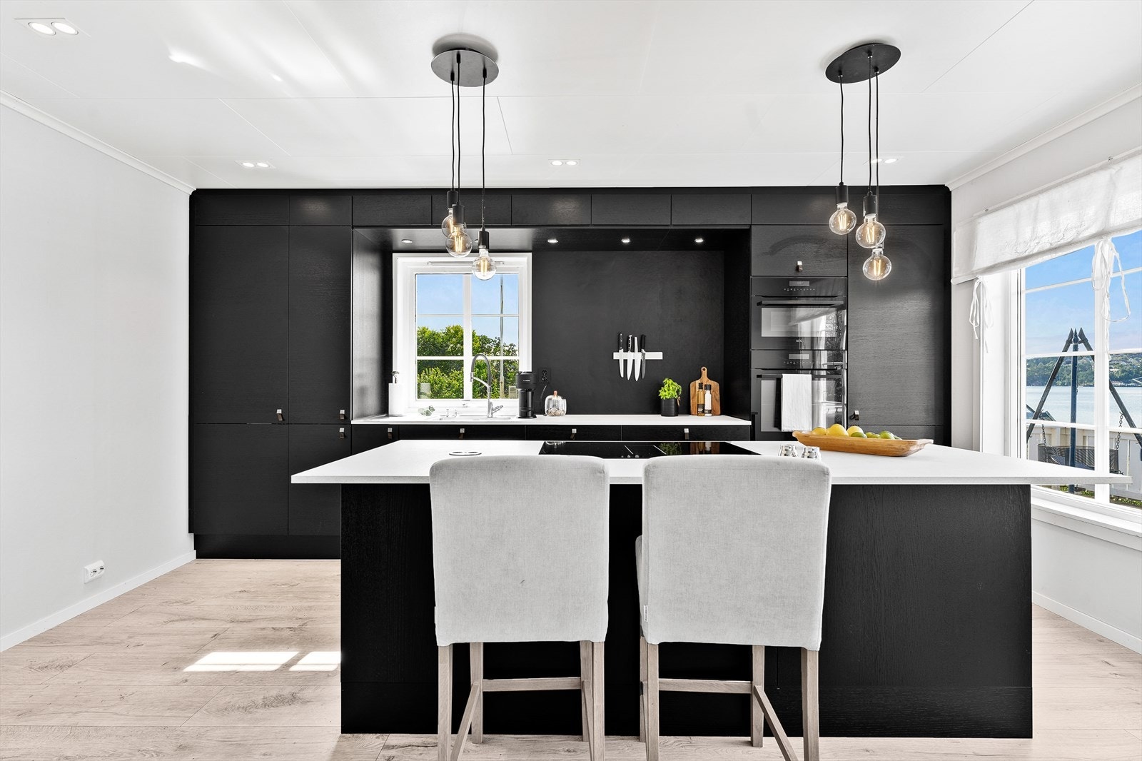 Kjøkkeninnredningen har en elegant løsning med mørke, glatte fronter og benkeplate av laminat. Galleribilde