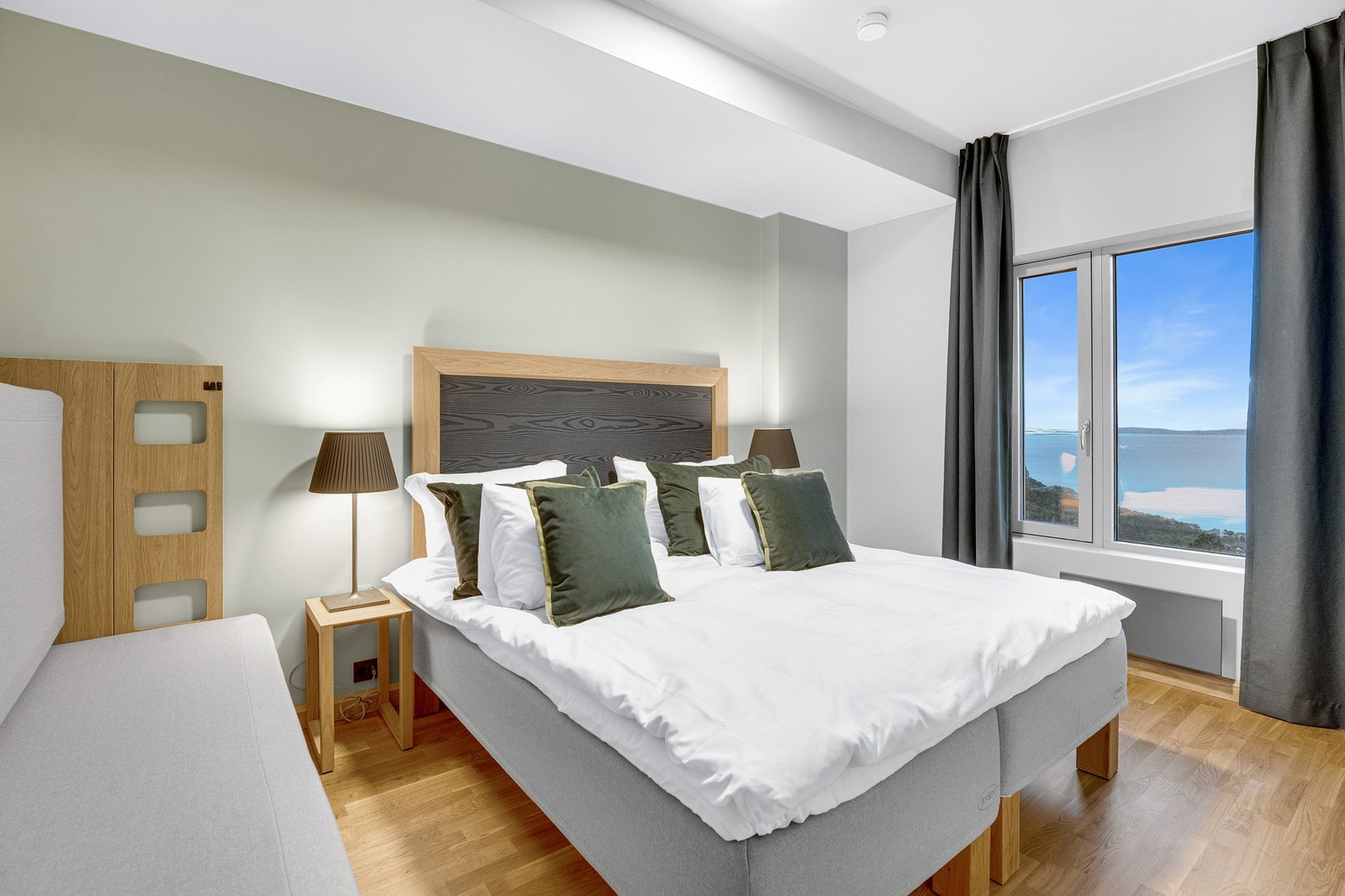 Hotelleilighet - Innbydende soverom med flott utsikt. Komfortabel seng med tilhørende nattbord og moderne belysning. Galleribilde