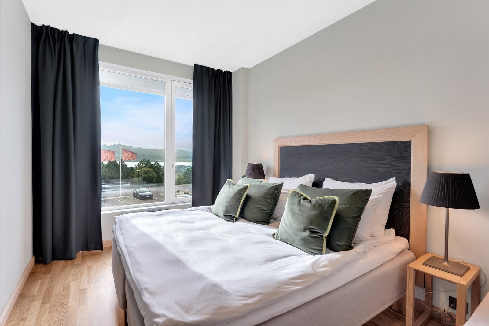 Hotelleilighet - Innbydende soverom med flott utsikt. Komfortabel seng med tilhørende nattbord og moderne belysning. Galleribilde