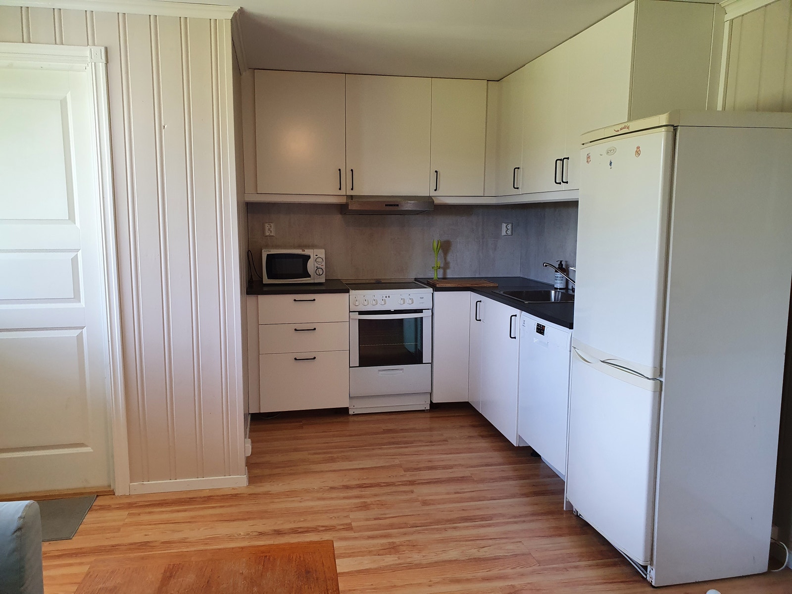 Kjøkken med komfyr, kombiskap og oppvaskmaskin Galleribilde