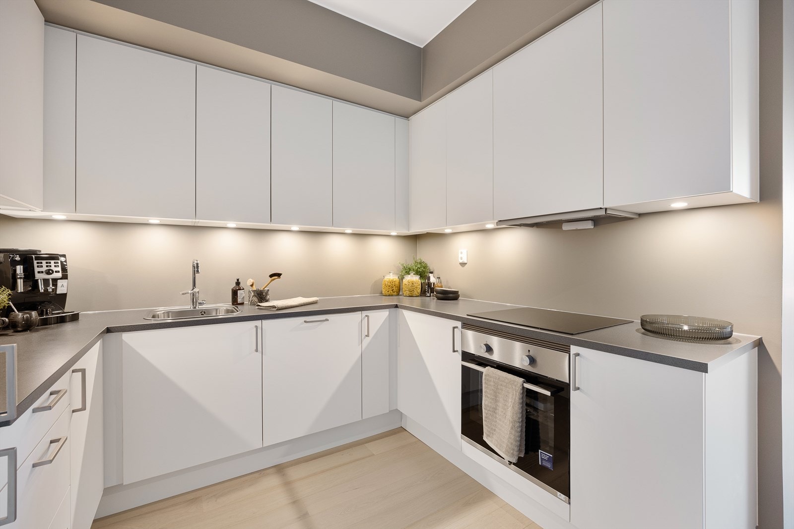 Kjøkkeninnredningen er i u-form med integrerte hvitevarer Galleribilde