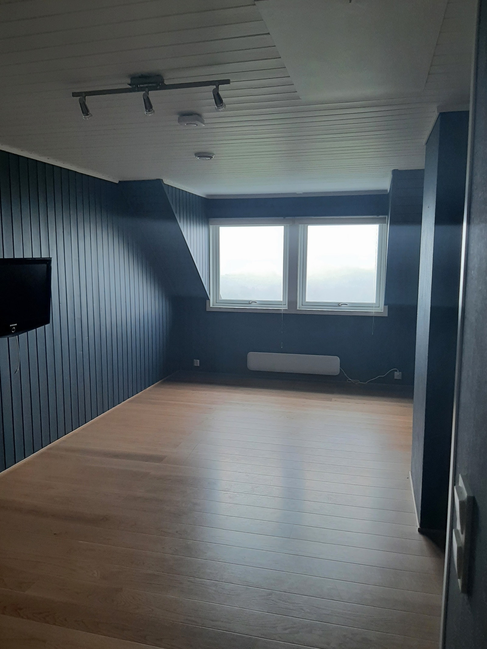 Leiligheten har stor stue med vinduer mot solnedgangen i vest Galleribilde