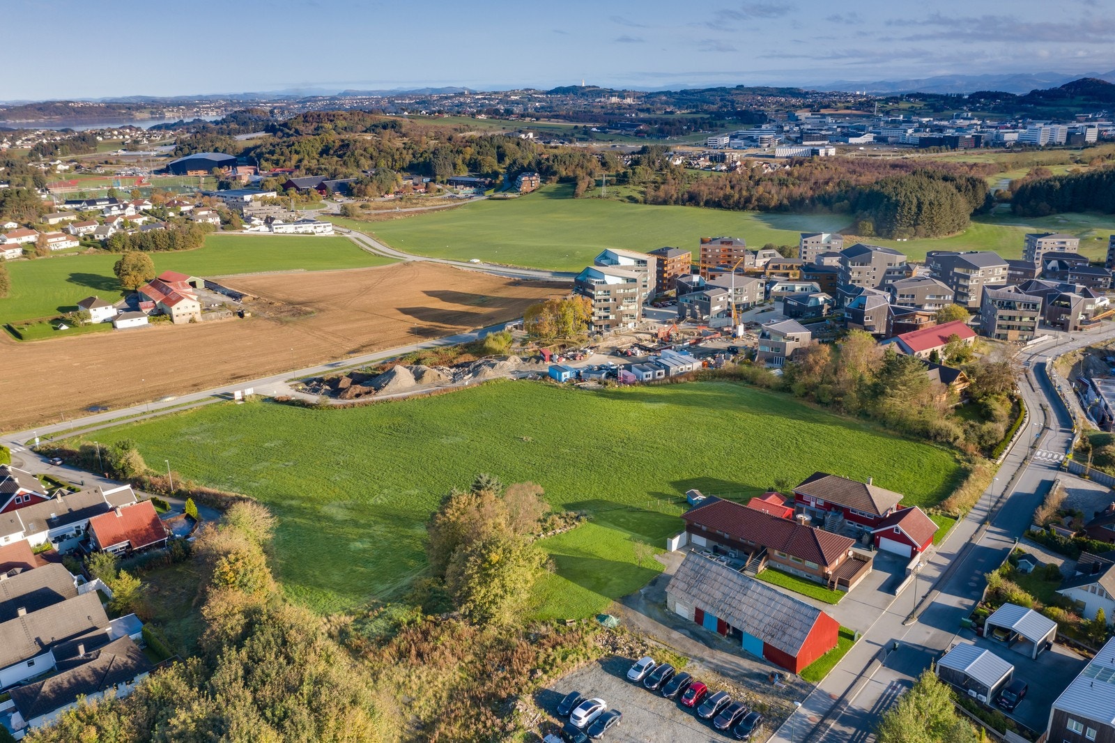 Den første blokken kommer der du ser grushaugene øverst til høyre i bildet , og rekkehusene kommer der bilene har parkert helt nederst til venstre i bildet Galleribilde