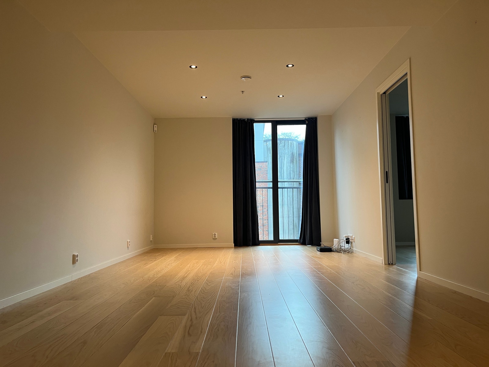 Stuen har åpen kjøkkenløsning. Kamera som står oppe i venstre hjørnet tilhører Verisure Boligalarm og kan demonteres dersom man ikke ønsker å tegne abonnement. Galleribilde