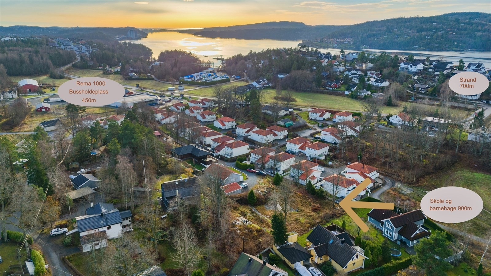 Dronebilde av område. Pil viser tomten. Galleribilde