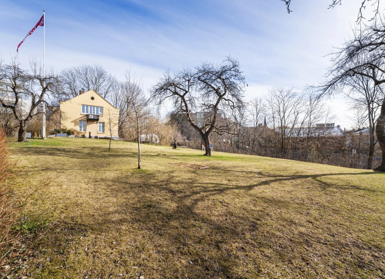 Inngjerdet bakgård med bord, griller og frukttrær tilgjengelig for utleier. Galleribilde