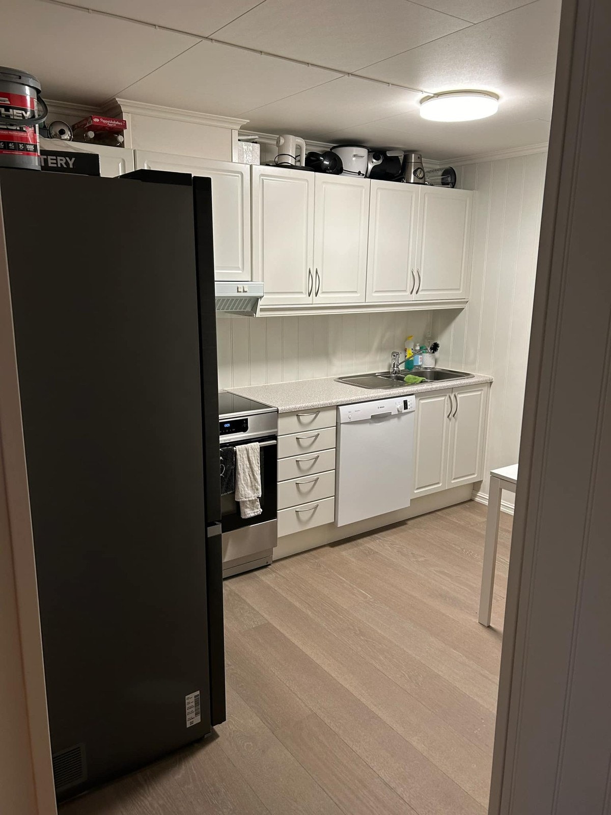 Kjøkken er møblert med kjøleskap komfyr og oppvaskmaskin Galleribilde