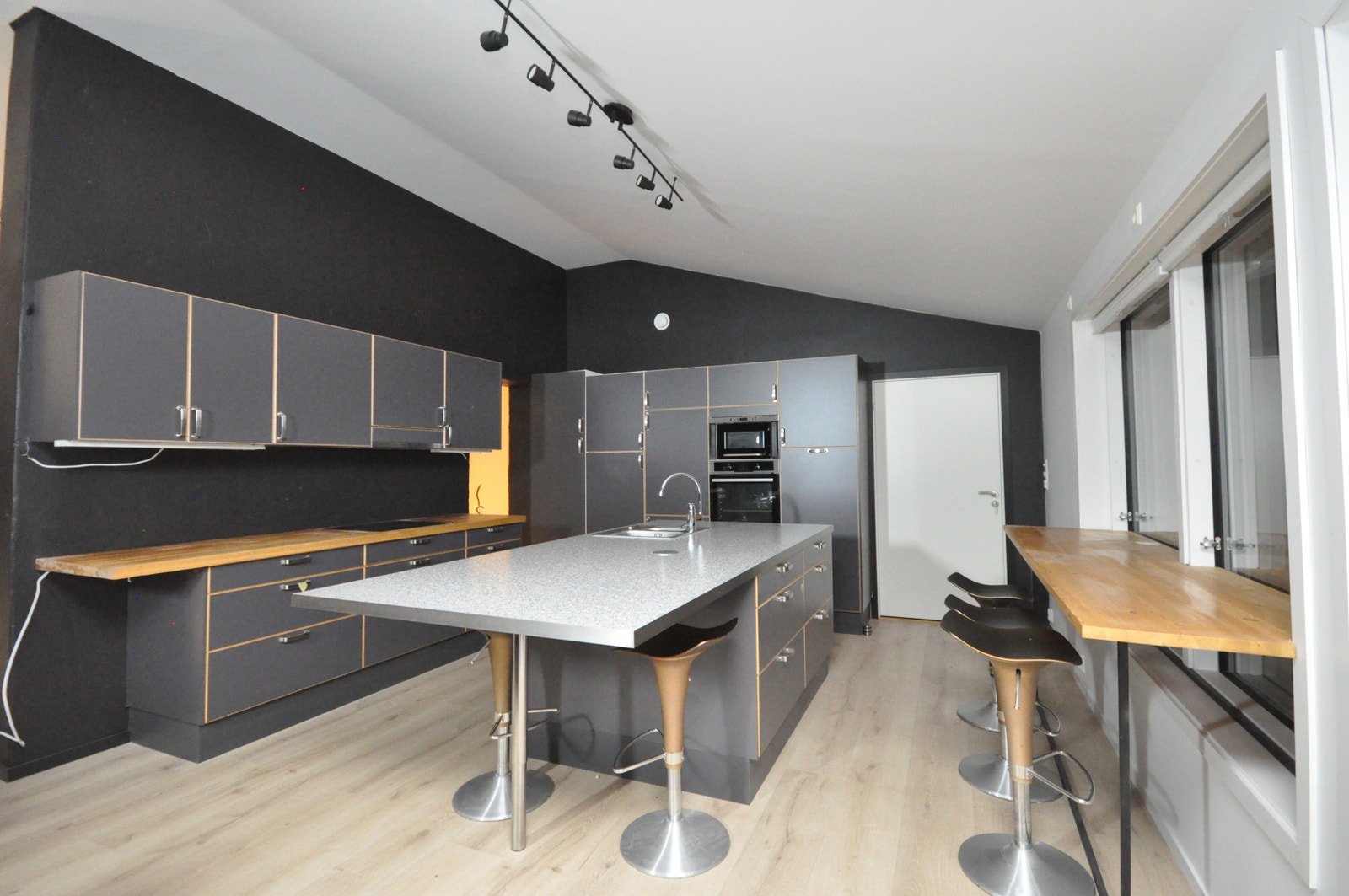 Stort kjøkken med mye skapplass, kjøkkenøy og integrerte hvitvarer Galleribilde