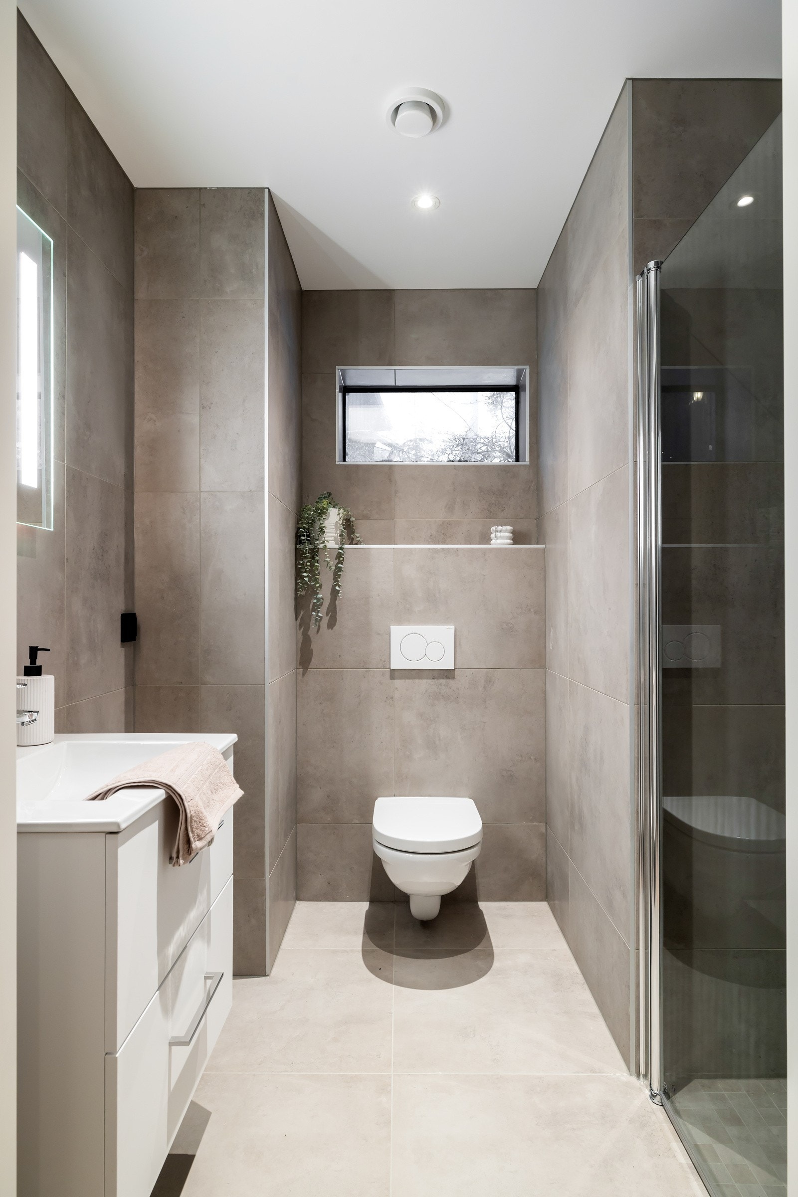 Toalettet er veggmontert med innebygget sisterne og trykknapp, som gir et stilrent og minimalistisk preg. Galleribilde