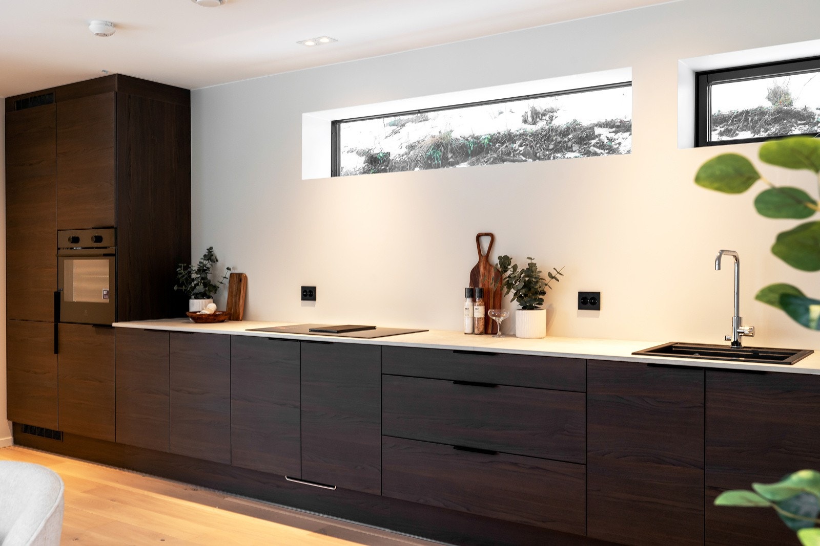 Naturlig lys fra vinduer ved tak over kjøkkenbenken, og høye vinduer på sidene gir en lys og innbydende atmosfære. Galleribilde