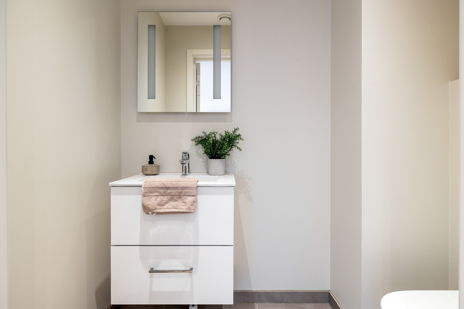 Toalettrommet er innredet meden servant med underskap, gulvet er storformatfliser på 60x60 cm og har varmekabler. Galleribilde