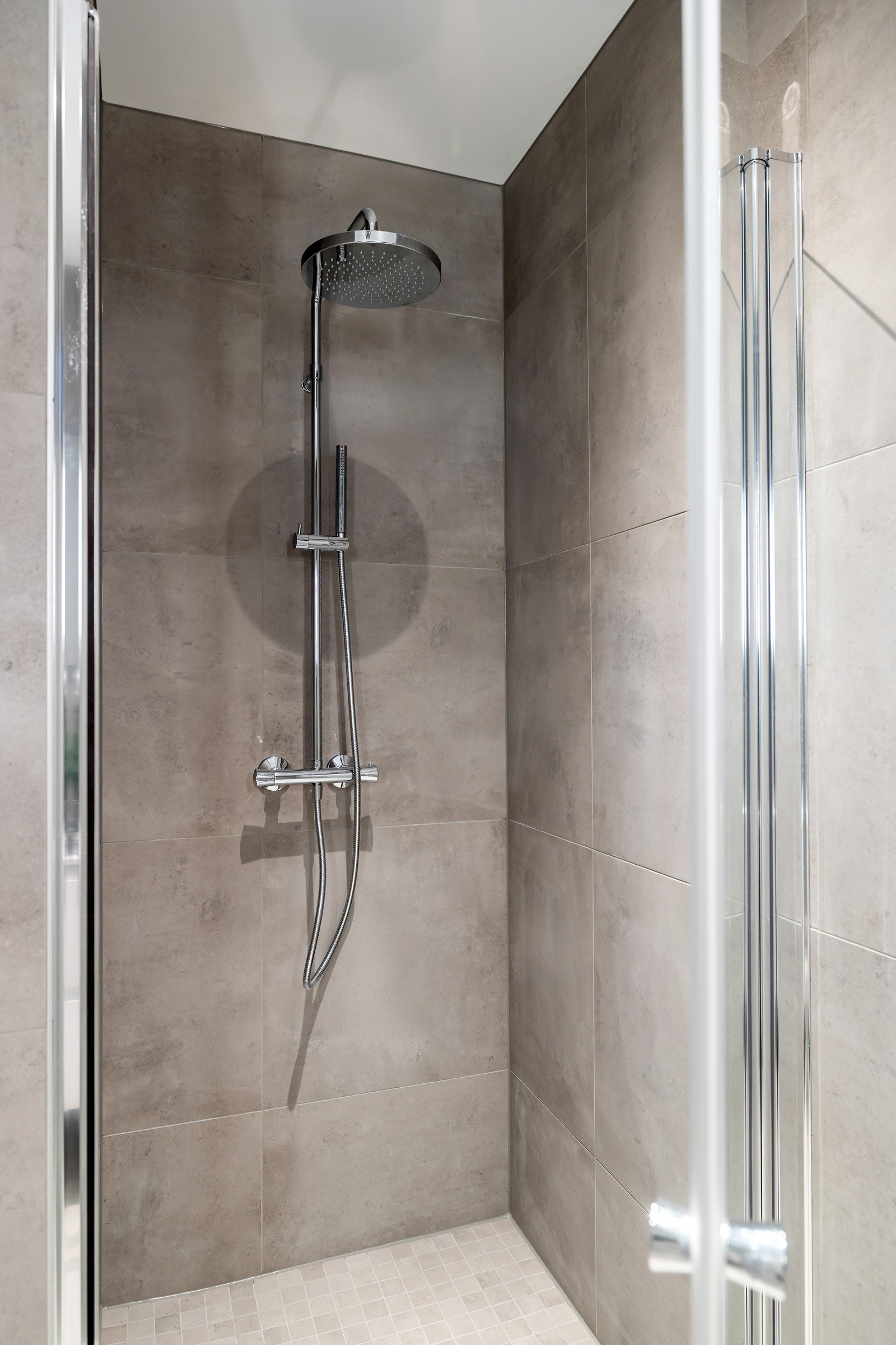 Badet har et romslig dusjhjørne med regnfallsdusj og innfellbare glassdører. Galleribilde