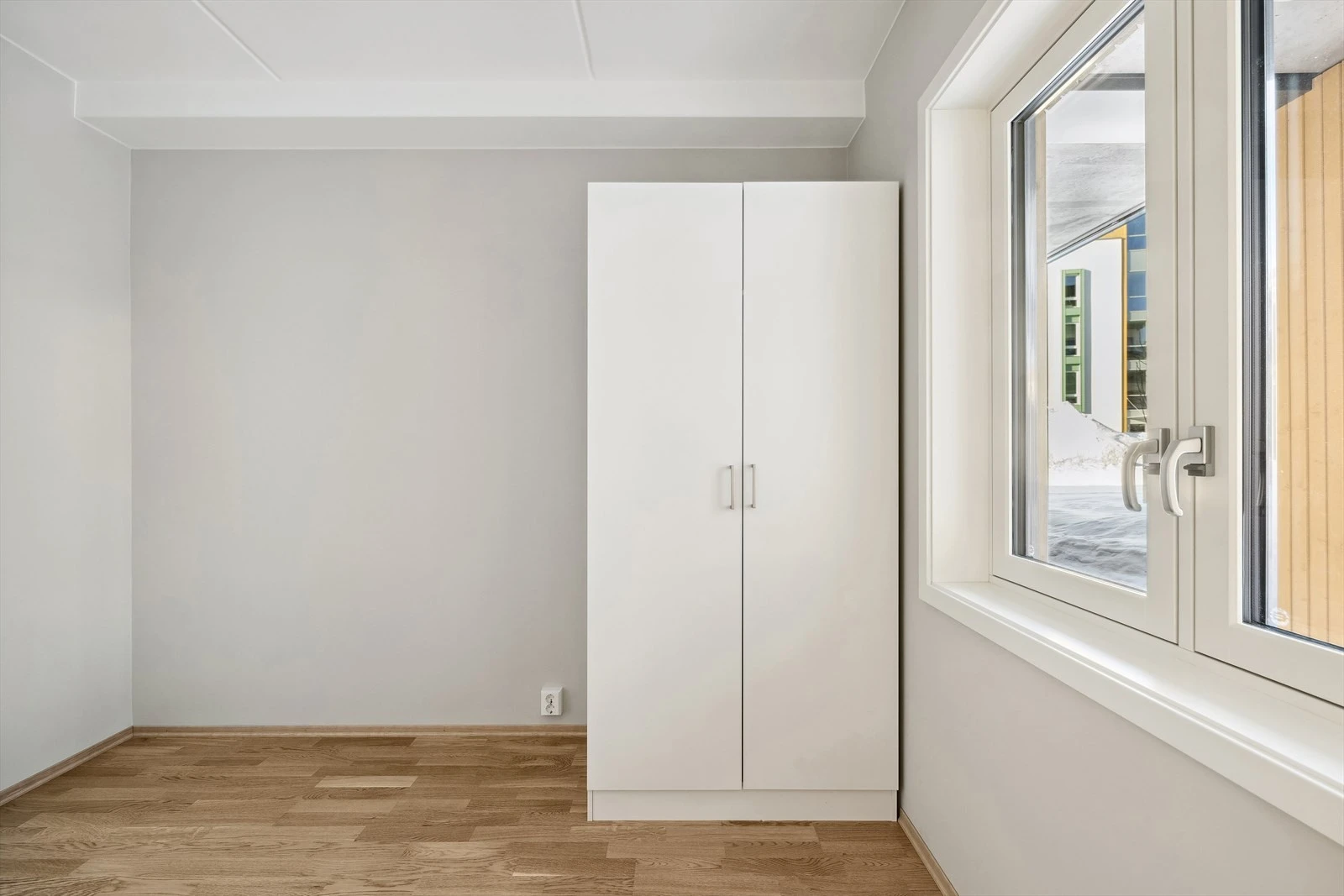 Soverom med stort vindu som vender mot rolig bakgård Galleribilde