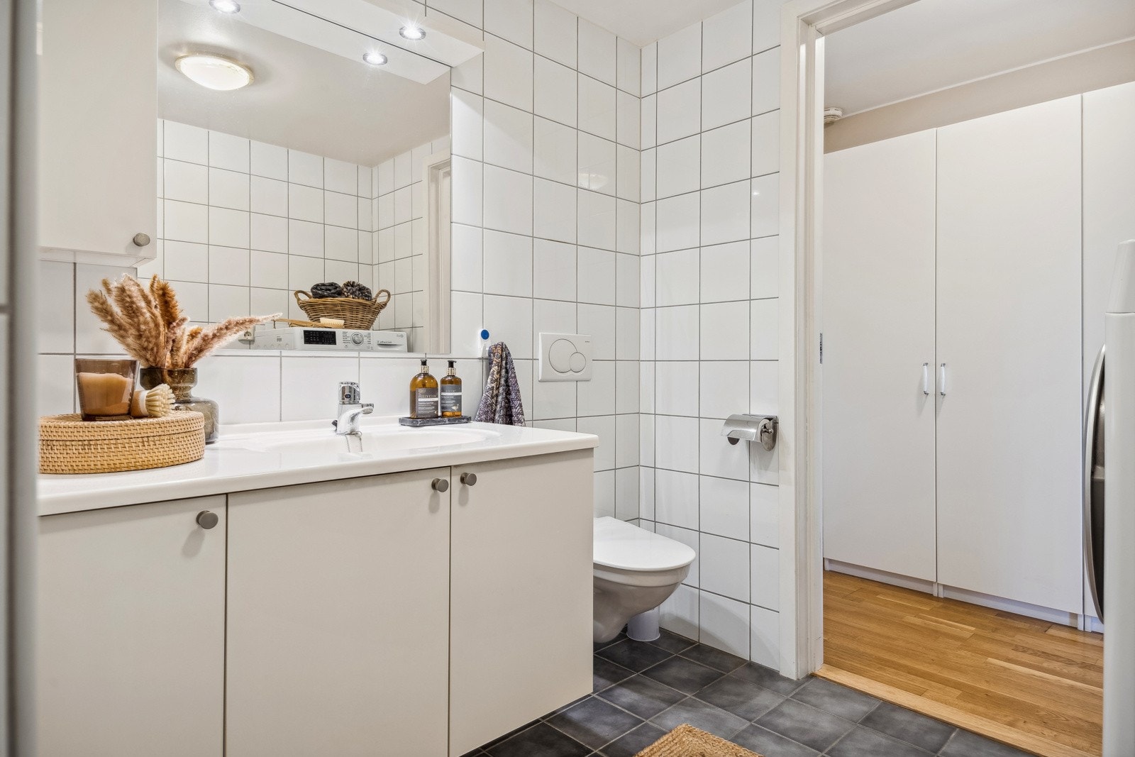 Moderne baderom fra byggeår med høy standard, hvor både gulv og vegger er flislagt for et stilrent og lettstelt uttrykk. Galleribilde