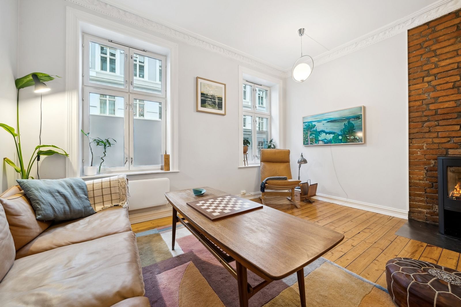 Innbydende stue med store vindusflater og tregulv Galleribilde