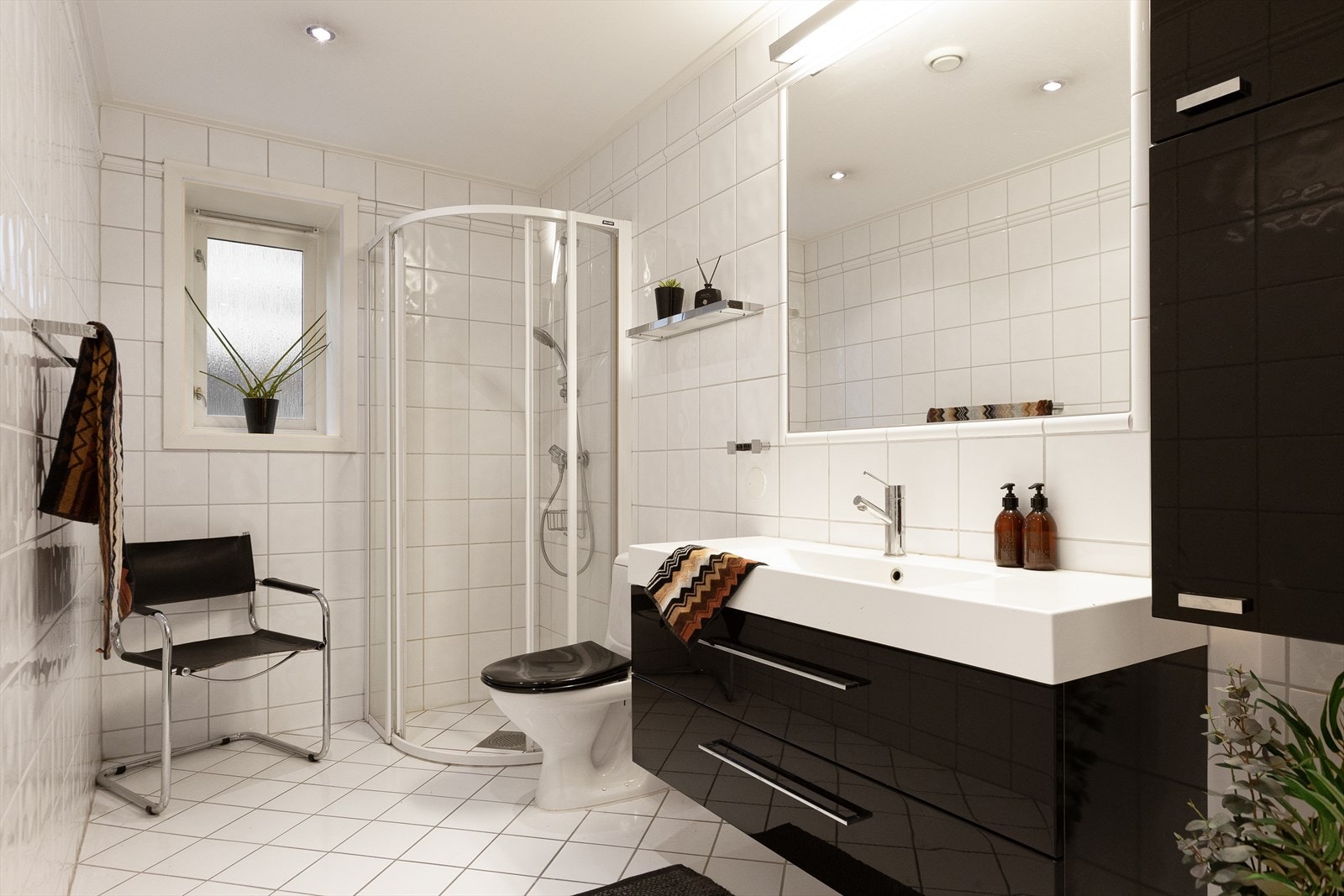 Flislagt baderom med varmekabler i gulvene og downlights i himlingen. Galleribilde