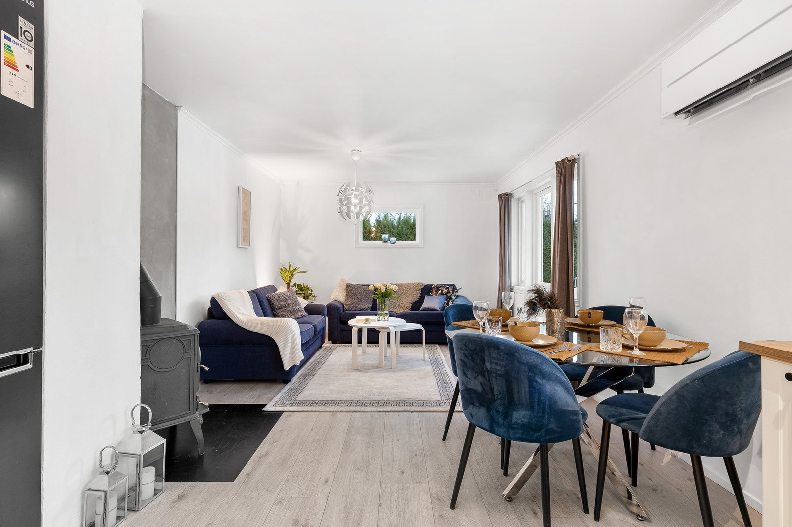Leiligheten har en stilren stue med fin plass til sofa og spisegruppe Galleribilde