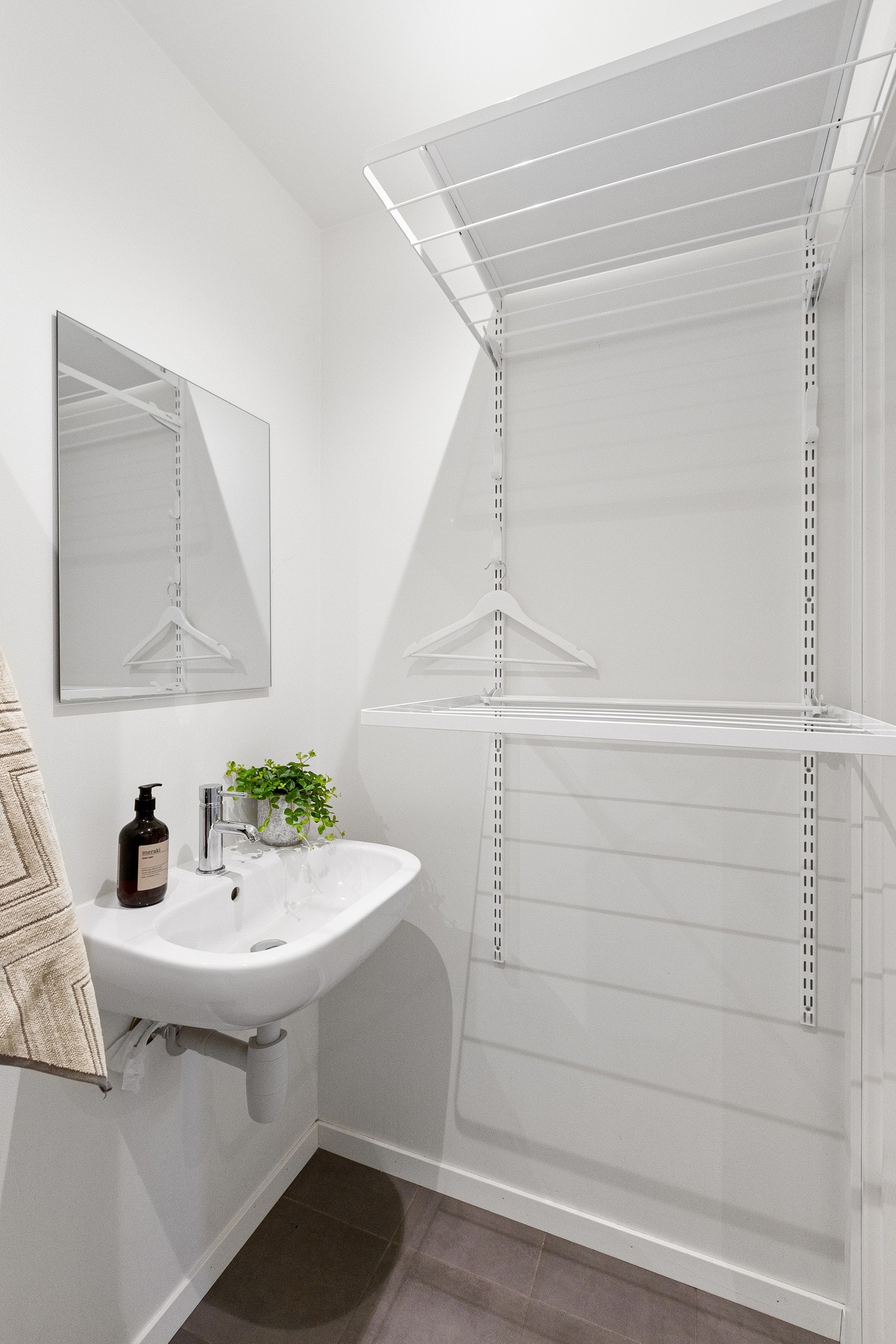 Rommet er utstyrt med vegghengt toalett, servant, speil og praktisk oppbevaringsmøbel. Galleribilde