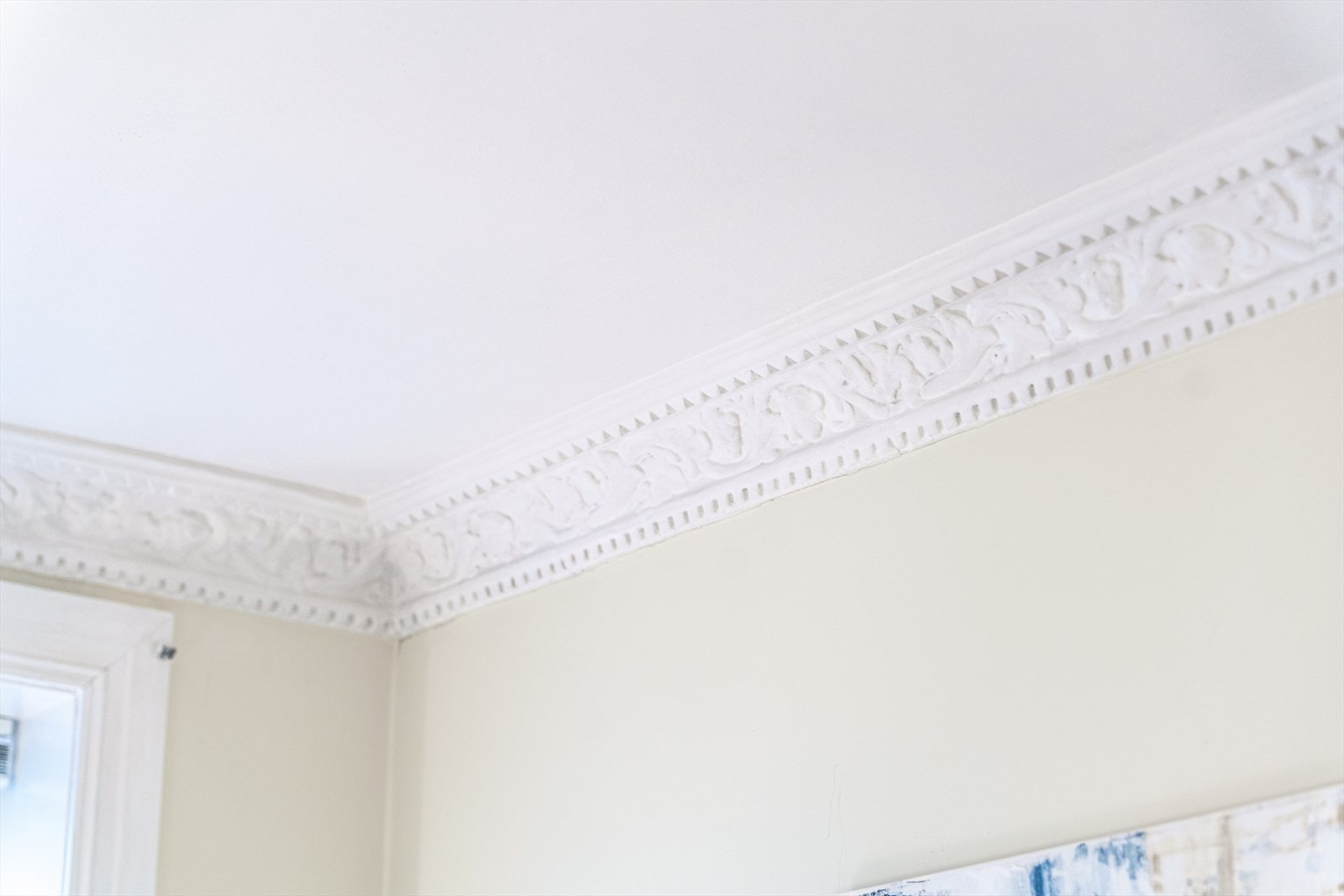 De klassiske detaljene, som rosett og stukkatur, tilfører rommet en tidløs eleganse Galleribilde