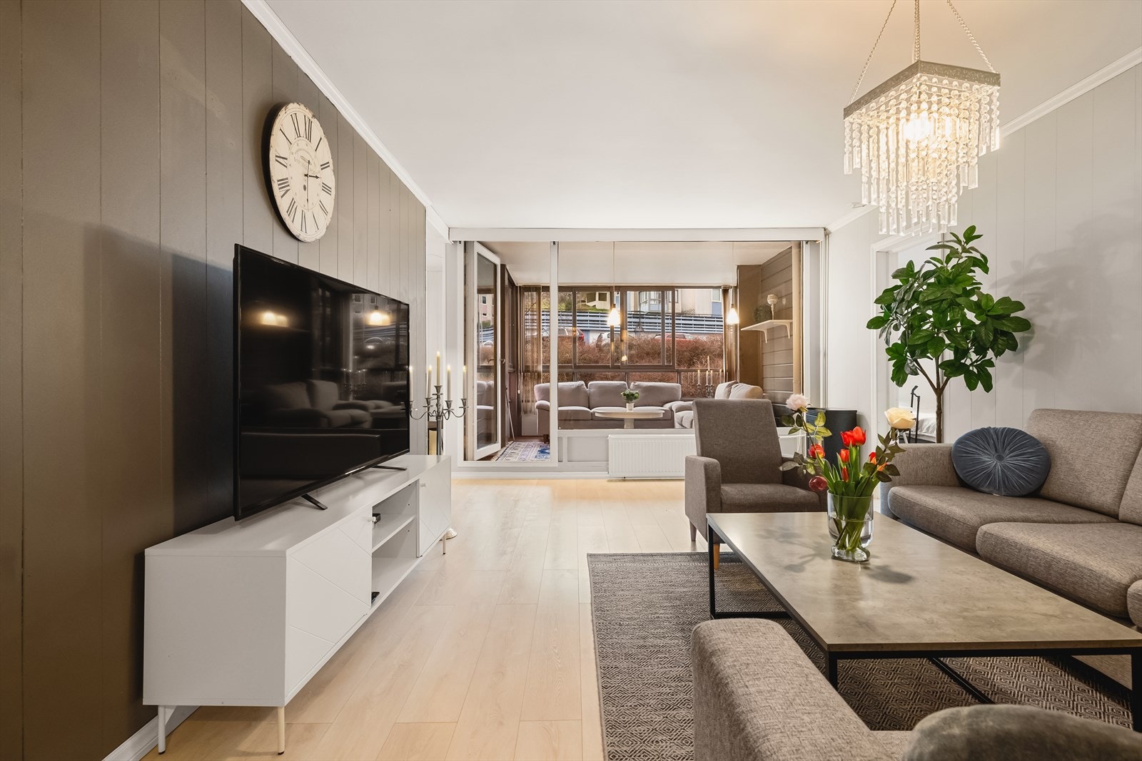 Stuen er leilighetens naturlige samlingspunkt, med store vinduer som gir rikelig med dagslys og en behagelig atmosfære Galleribilde